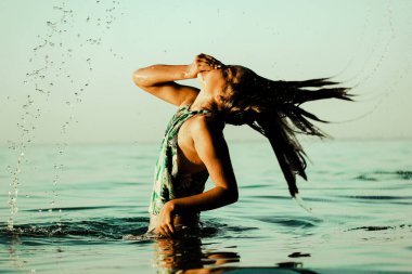 Teenage girl 10-13 years old frolicking playing in blue water. A child dives in and out of a water. Little girl has fun in sea ocean on summer vacation. Schoolgirl with wet hair in swimsuit having fun clipart