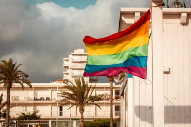 Renkli gökkuşağı LGBT bayrağı güneşli bir günde gökyüzüne karşı rüzgarda dalgalanıyor. Gay geçidi, Gurur Ayı 2025 Çeşitlilik sembolü. Çok renkli ipek dokusu.