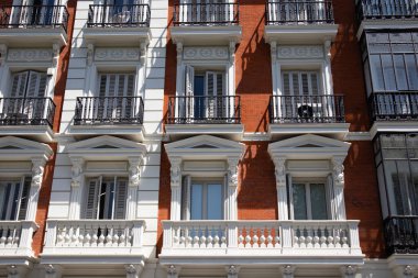Madrid İspanya 1 Mayıs 2022 Eski bir kırmızı tuğlalı ev cephesi, balkonlar. Tarihi şehir merkezinde sıva olan bir apartmanın ön manzarası.