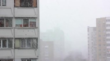 Kış mevsiminde şehir manzarası. Dondurucu havada yağan kar taneleriyle birlikte kar yağışı. Aralık, Ocak, Şubat. Çok katlı bina..