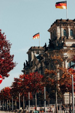 Berlin, Almanya. 2 Ekim 2022 Alman parlamento binası. Sonbahar gününde mavi gökyüzüne karşı bayrakları olan. Eski Avrupa mimarisi ile birlikte hükümet çeyreği.