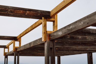 Tahta çerçeve kiriş yapısı. Ahşap panellerden yapılmış bir yapının yakın plan fotoğrafı. Grunge ahşap araba blokları. Tahtalar ve sütunlar gökyüzüne karşı. 