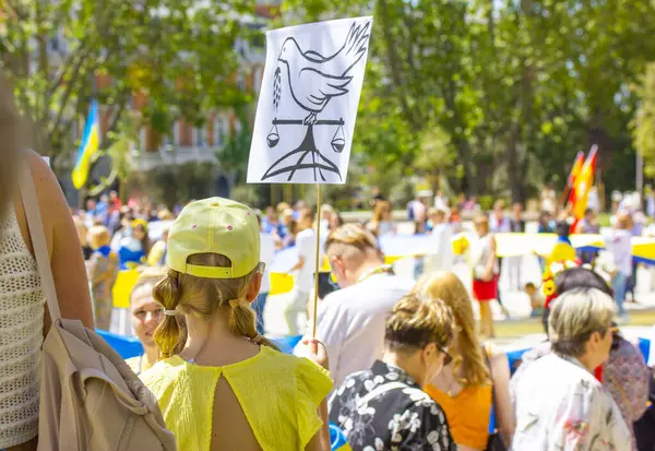 Madrid, İspanya. 1 Temmuz 2022 Ukrayna 'yı desteklemek için savaşa karşı bir miting. Barış sembolü olan pankartlı insanlar. Putin 'in savaş konseptini durdurun..