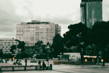 Akşamları soyut şehir geçmişi. Uzun kulelerin, gökdelenlerin ve sokaktaki insanların bulanık siluetleri. Alacakaranlıkta sokak lambaları. Şehir manzarası