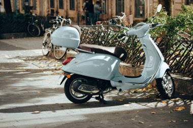 Fransa, Paris. 8 Ekim 2023. Şehrin caddesinde park etmiş mavi bir scooter. Küçük motorlu bir araç. Eski moda Vespa scooter 'lar küçük, rahat kasaba sokaklarında.