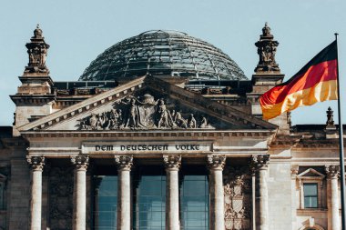Berlin, Almanya. 2 Ekim 2022 Alman parlamento binası ve bayrak direğinde Alman bayrağı. Hükümet, politika konsepti. Sütunları olan eski bir bina. 