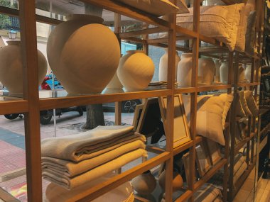 Çömlek vazoları ve mum tutacakları bir rafa dizilir, önlerinde desenli yastıklar kırsal bir manzara yaratır. Sanatsal olarak düzenlenmiş toprak vazosu