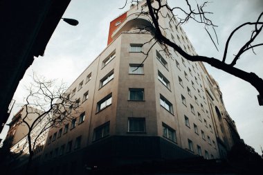 Madrid, İspanya 1 Ekim 2024 Mimari bir manzara bulutlu bir gökyüzünün altında çıplak dallarla sahnenin alt görüntüsünü yakalıyor.