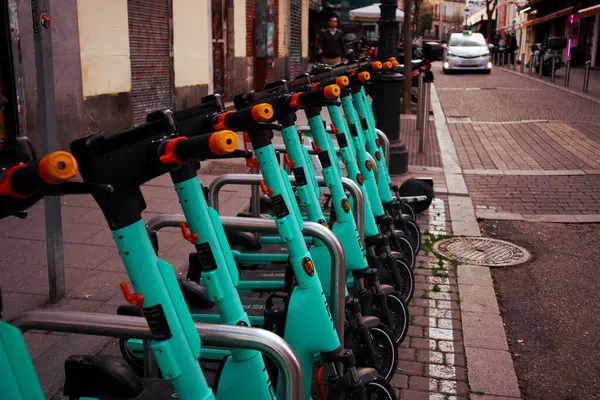 Madrid, İspanya 2 Mart 2024 Bir dizi elektrikli scooter şehir caddesi boyunca park halinde, sürdürülebilir bir ulaşım aracı sunuyor. Kentsel hareketlilik. 