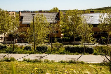 Madrid Barajas, İspanya 1 Mayıs 2024 güneşli bir günde, kenar mahallelerde ağaçların oluşturduğu modern evlerin mimarisi ön plana çıkıyor.. 