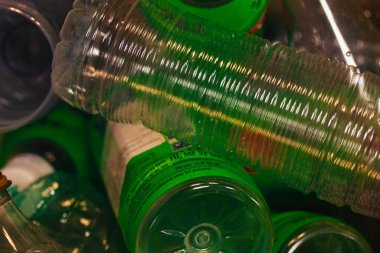 Dökülen plastik şişelerden oluşan bir koleksiyon. Dokuları ve renkleri vurguluyor. Bu resim geri dönüşümü ve çevresel farkındalığı sembolize ediyor.