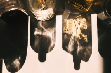 Tepeden çekilen bir çekim, yüzeyde soyut şekiller oluşturan cam nesneler tarafından oluşturulan bir ışık ve gölge oyunu yakalar. Bu mistik bir atmosfer ekler..