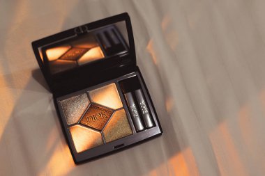 Paris, Fransa 1 Mayıs 2025. Beyaz bir tekstil yüzeyinde parlak bir ışık hüzmesi içinde göz alıcı bir makyaj paleti Dior. Kadınlar için lüks bir kozmetik ürünü. 