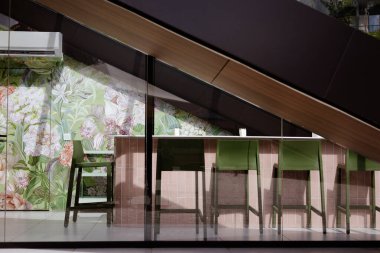 Bukovel, Ukrayna 12 Mayıs 2025 İç mekanda yüksek sandalyeli, çiçekli duvar kağıtlı modern iç tasarımı olan kapalı bir kafeterya sergileniyor.