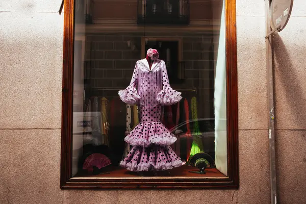 Madrid, İspanya 7 Mayıs 2023 Bir mağaza vitrininde güzel bir flamenko elbise sergilenmektedir İspanyol kültürü sergilenmektedir. İspanya 'nın geleneksel giysileri