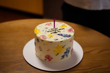 Çok güzel dekore edilmiş mum ışığında bir pasta, özel bir doğum günü kutlaması için mükemmel. Renkli çiçeklerle süslenmiş güzel bir pasta ve tek bir mum, kutlama için mükemmel..
