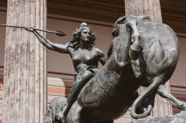Berlin, Almanya 2 Ekim 2024 Bronz mimari bir heykel, klasik sanat ve gücü somutlaştıran, yükselen at mızrağı süren bir kadını resmediyor.