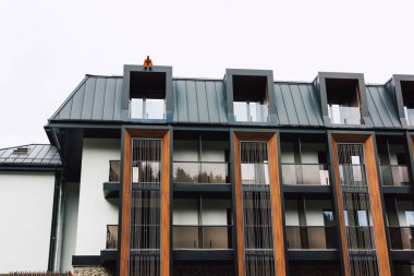 Bukovel, Ukrayna 12 Mayıs 2025 Modern bina cephesi eşsiz çatı tasarımı ve cam balkonları ile. Modern bir mimari bina Benzersiz bir çatı çizgisi 