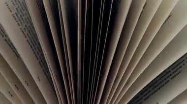 Sayfaları açık bir kitap, ilgi çekici bir kompozisyon yaratıyor. Sayfaların açıldığını gösteren açık bir kitabın kapanışı. Bakış açısı kitapların iç kısımlarına benzersiz ve soyut bir bakış açısı sunuyor..