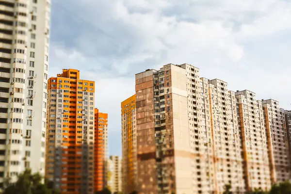 Kyiv, Ukrayna. 7 Haziran 2025 Bulutlu bir gökyüzüne karşı bir grup bina şehir manzarası yaratıyor. Gökyüzünün altında birçok penceresi olan uzun bir apartman. Arka planda başka binalar da görünüyor..