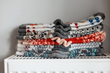 Soğuk bir güne hazır renkli, desenli yün çoraplar yığını. Renkli, desenli yün çoraplar, düzgünce yerleştirilmiş ve giyilmeye hazır, radyatörün üzerinde dinleniyor. Ukrayna 'nın motivasyon ve düzeni