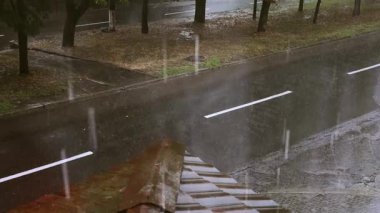 Şehir sokaklarına düşen yağmur damlalarıyla dolu yağmurlu bir manzara huzurlu ve ıslak bir manzara yaratıyor. Yağmur damlaları soğuk sonbahar gününde ağaçlarla tamamlanmış arabaların olduğu bir yola düşer. Fırtınalı hava, kasırga.