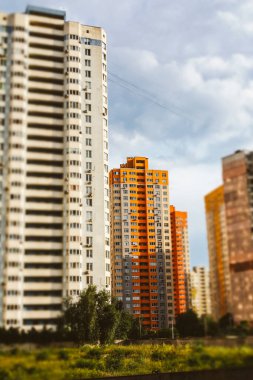 Kyiv, Ukrayna. 7 Haziran 2025 Bulutlu bir gökyüzüne karşı bir grup bina şehir manzarası yaratıyor. Gökyüzünün altında birçok penceresi olan uzun bir apartman. Arka planda başka binalar da görünüyor..
