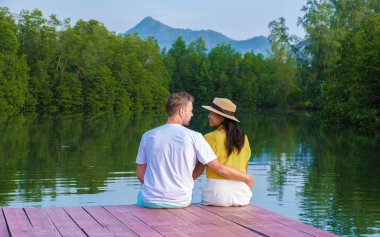 Koh Chang Tayland 'daki Klong Gölü' nde gün batımını izleyen bir çift kadın ve erkek.. 