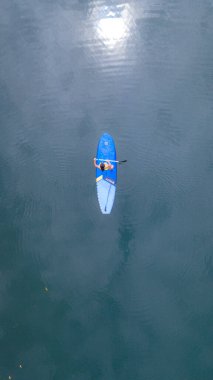 Kadınlar Koh Chang Tayland 'da, yağmur ormanlarındaki Klong Gölü' nde bir yemek masasında kürek çekiyorlar. stand-up pedalları