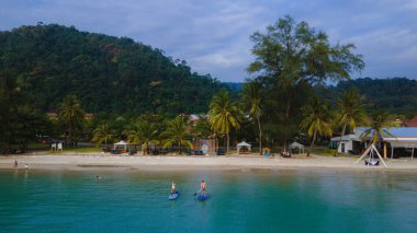 Erkekler ve kadınlar Koh Chang Tayland 'da bir yemek masasında kürek çekiyorlar. stand-up pedalları