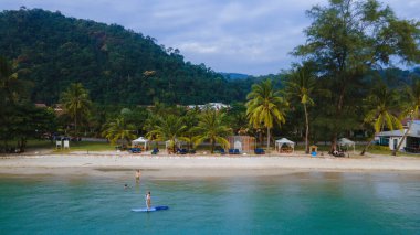 Kadınlar Koh Chang Tayland 'da yemek masasında kürek çekiyor. stand-up pedalları