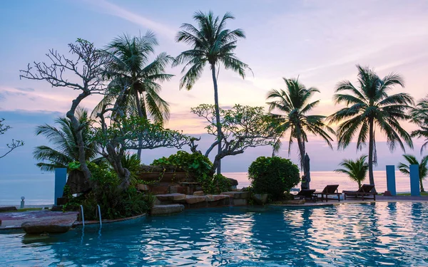 Gün Batımında Palmiye Ağaçları Olan Tropik Bir Yüzme Havuzu Günbatımında — Stok fotoğraf