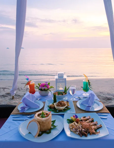日没時のビーチでのディナーテーブルのクローズアップ 日没時のタイのコ チャンのビーチでのロマンチックなディナー ビーチで夕食とテーブル — ストック写真