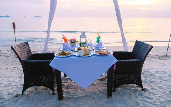 석양이 해변에서 식탁을 클로즈업하고 녘에는 해변에서 낭만적 식사를 해변에서 식사를 — 스톡 사진