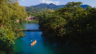 Bir çift erkek ve kadın Koh Chang Tayland tropikal adasında kayak yapıyor. Yağmur ormanının yukarısından drone görüntüsü Nehirde bir çift kanoyla