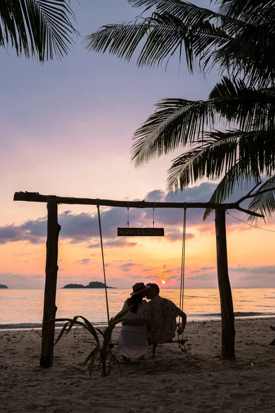 在泰国高昌岛上的一个热带海滩上 一对男女在秋千上观看日落 — 图库照片