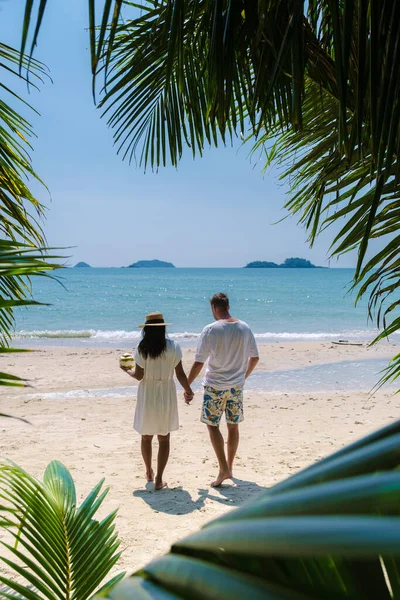 在泰国海滩上散步的一对夫妇的棕榈树之间的景色 在高昌热带海滩散步的男男女女 — 图库照片