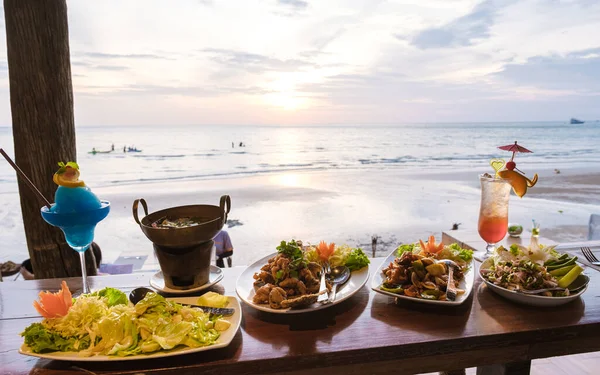 魚やタイ料理とビーチで日没時のディナーテーブル ロマンチックなディナーテーブル — ストック写真