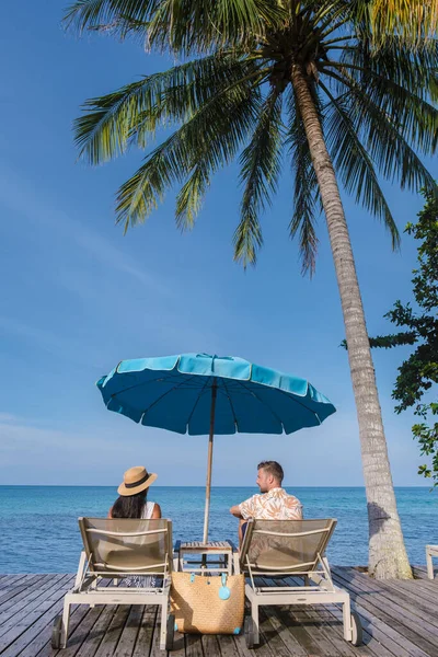Muži Ženy Relaxující Moře Plážové Posteli Pod Modrým Deštníkem Během — Stock fotografie