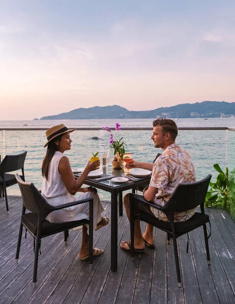 Romantic dinner on the beach with Thai food during sunset on the Island of Phuket Thailand. Couple men and women having a romantic dinner on the beach