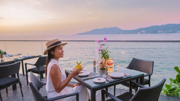 Romantic dinner on the beach with Thai food during sunset on the Island of Phuket Thailand. women having a romantic dinner on the beach