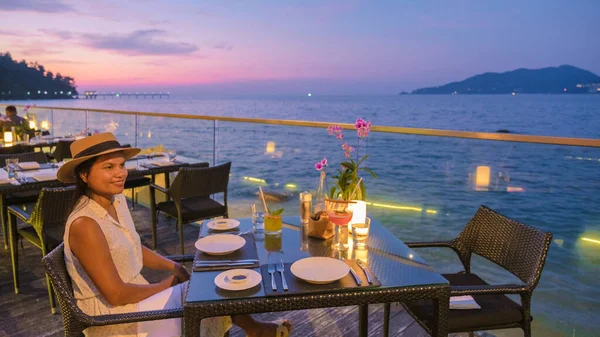 Romantic dinner on the beach with Thai food during sunset on the Island of Phuket Thailand. women having a romantic dinner on the beach