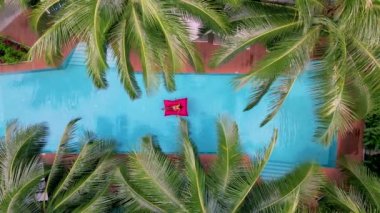 Yukarıdan bir yüzme havuzu manzarası, Asyalı Taylandlı kadınlar yüzme havuzunda, drone manzarası. 