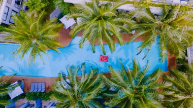 Havuz manzaralı palmiye ağaçları, yukarıdan havuz manzaralı kadınlar.