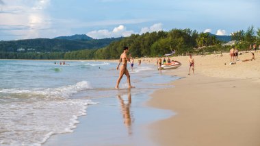 Bang Tao plajı Phuket Tayland Kasım 2002, insanlar Tayland 'da yüksek mevsimde akşam güneşinde dinleniyorlar.