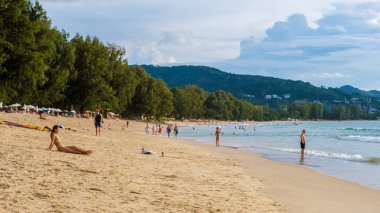 Bang Tao plajı Phuket Tayland Kasım 2002, insanlar Tayland 'da yüksek mevsimde akşam güneşinde dinleniyorlar.