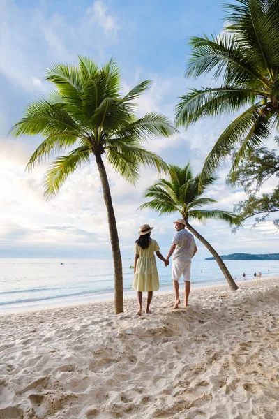 白い砂浜とヤシの木 バンタオビーチでビーチの夕日を見てヤシの木に立っている男性と女性のカップルプーケットタイ — ストック写真
