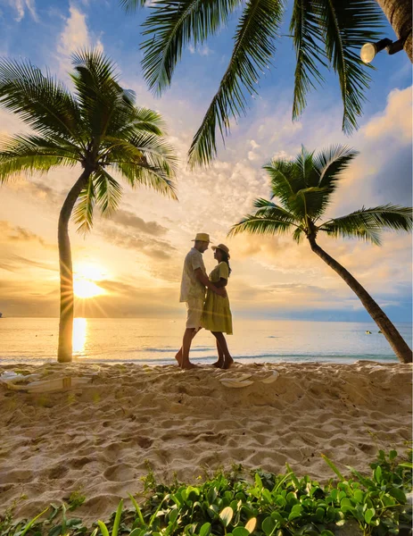 白砂とヤシの木でビーチで夕日を見て愛を作るキスをする男性と女性のカップル バンタオビーチプーケットタイ — ストック写真