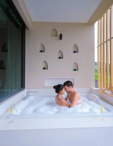 couple drinking champagne in a jacuzzi during honeymoon vacation
