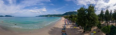 Patong plajı Phuket, plaj sandalyeleri ve palmiye ağaçları olan tropik plaj manzarası.. 